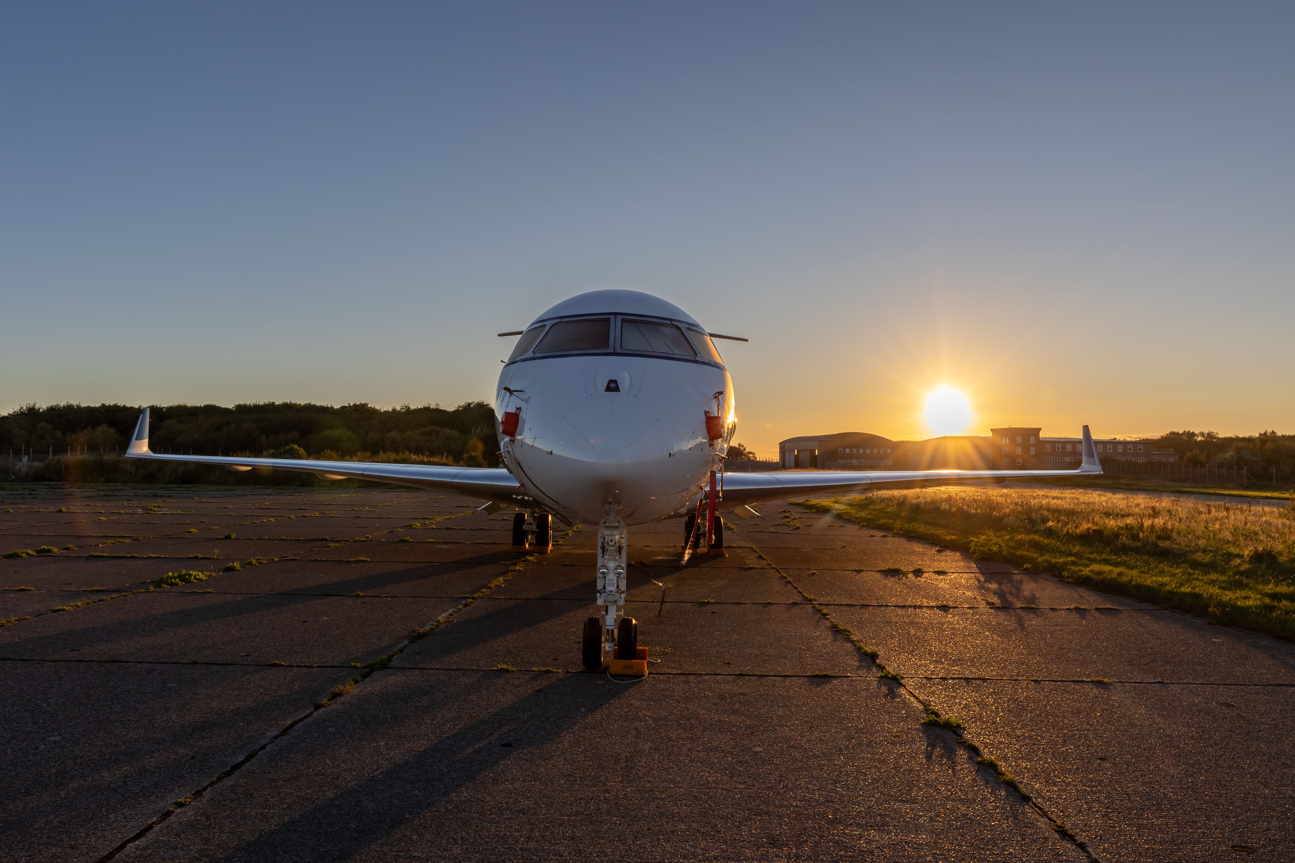 Private jet waiting on the runway at sunset for an exclusive luxury trip.